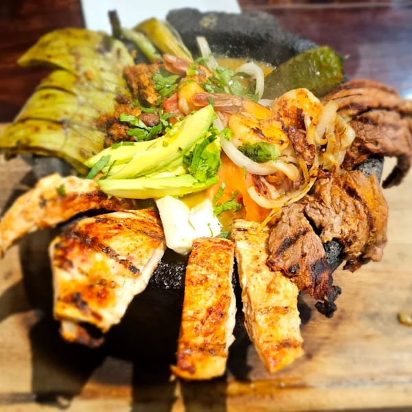 Señor Jose's molcajete with grilled steak, chicken, shrimp, avocado, onions, and peppers.